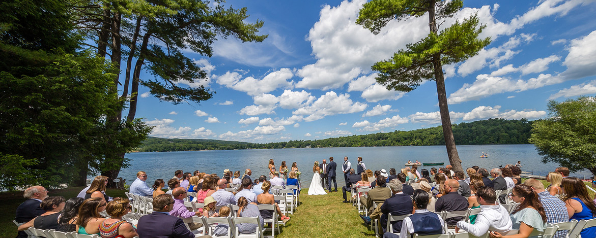 boda en un campo de hierba frente a un lago