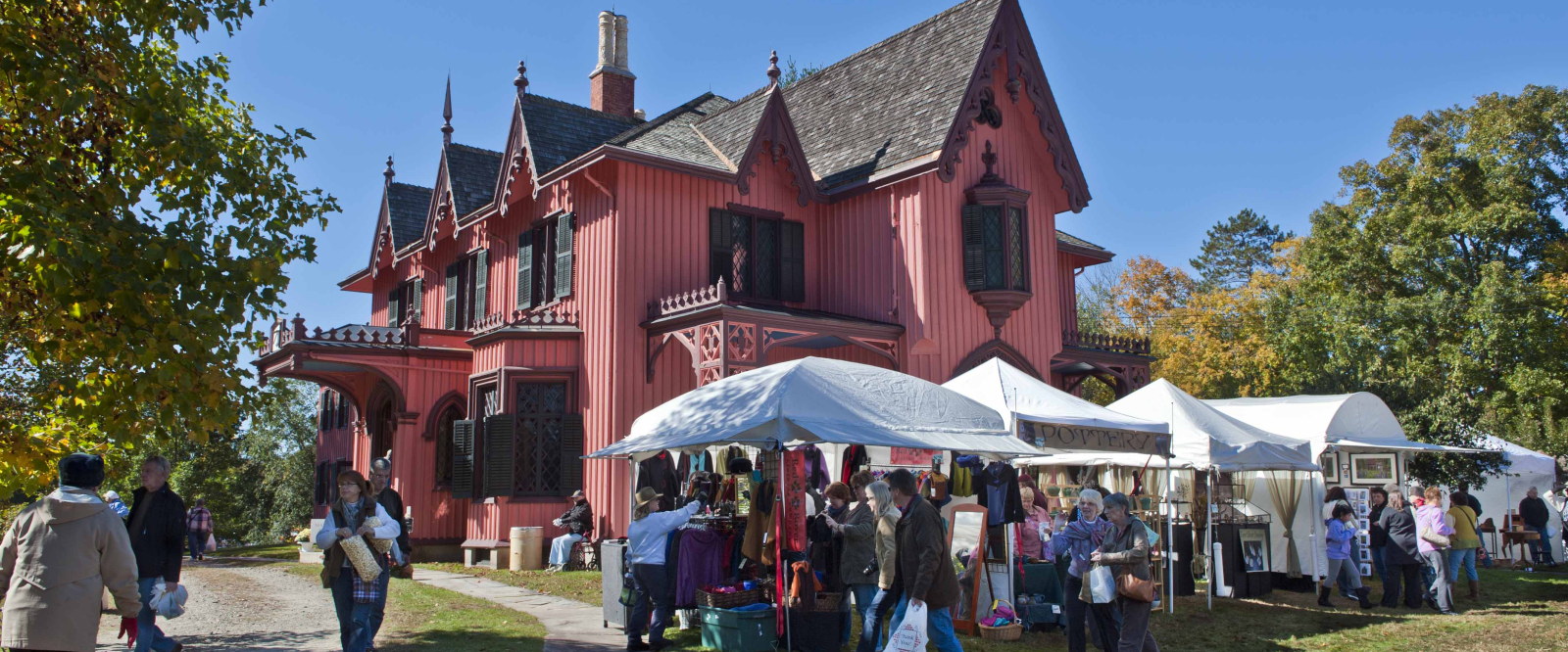 Roseland Cottage with market tents and people at outdoor fair