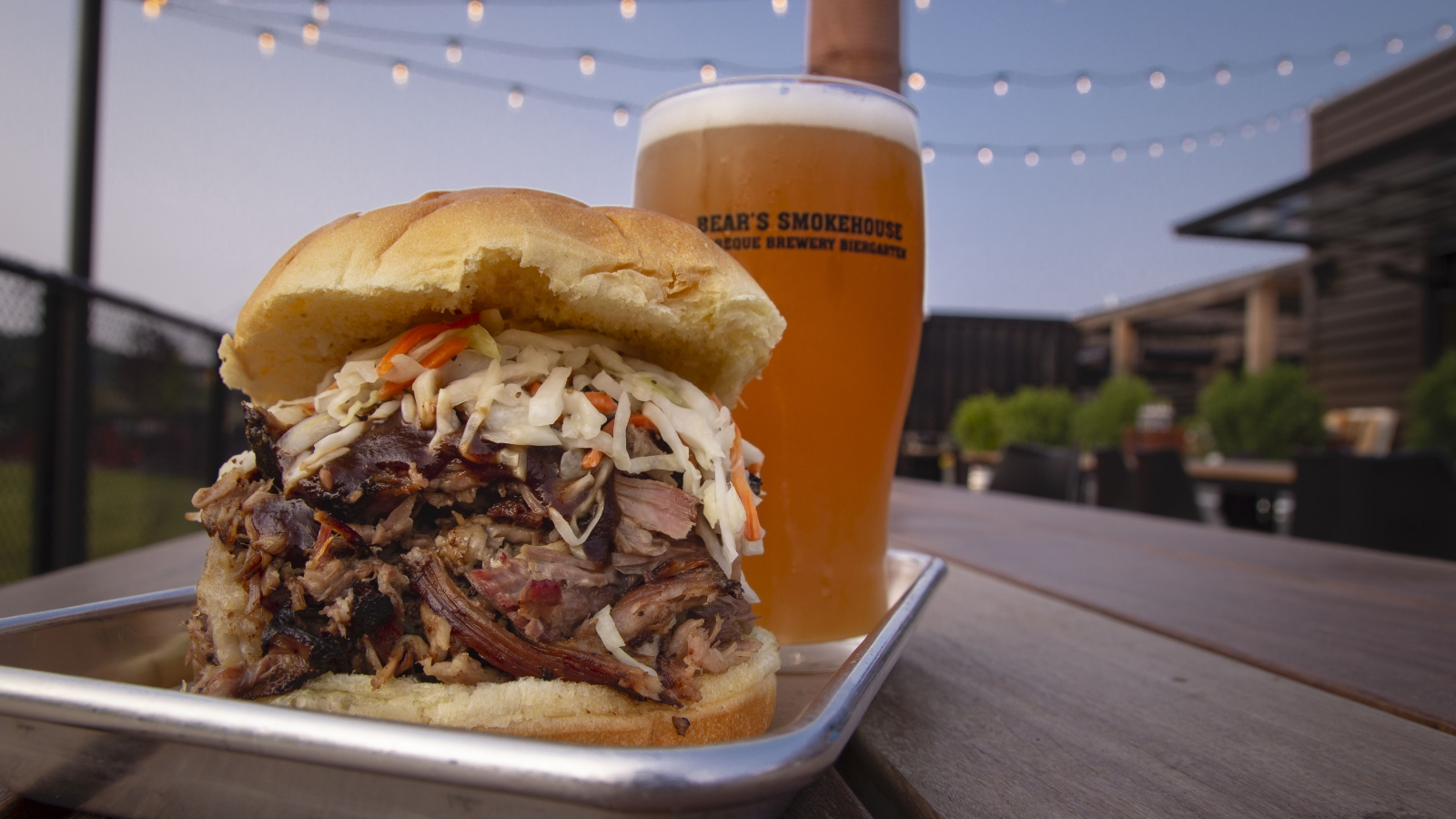 Barbecue pulled pork sandwich with coleslaw and beer at outdoor patio