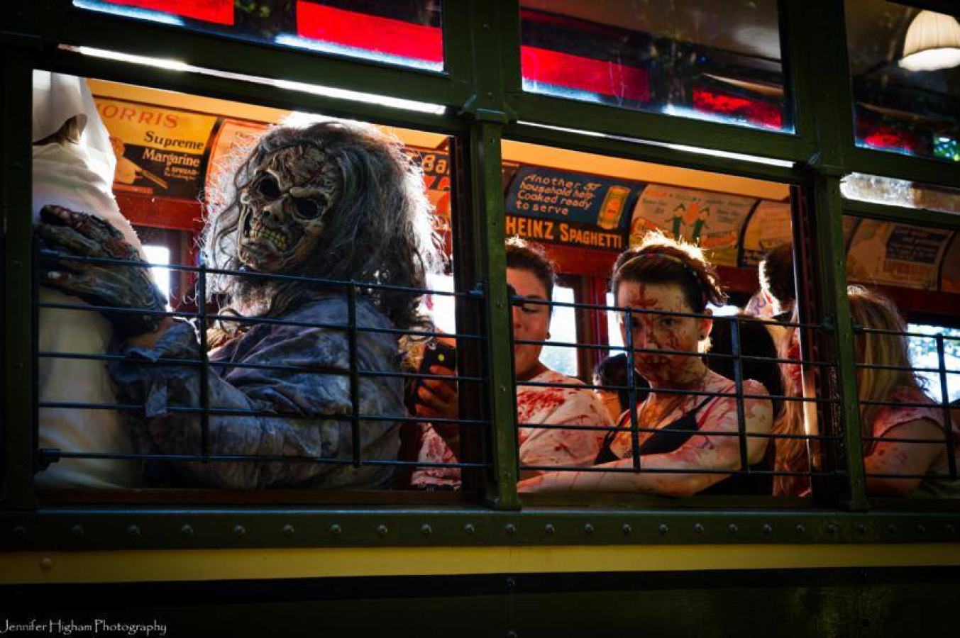 People in gruesome zombie costumes sitting inside a trolley car