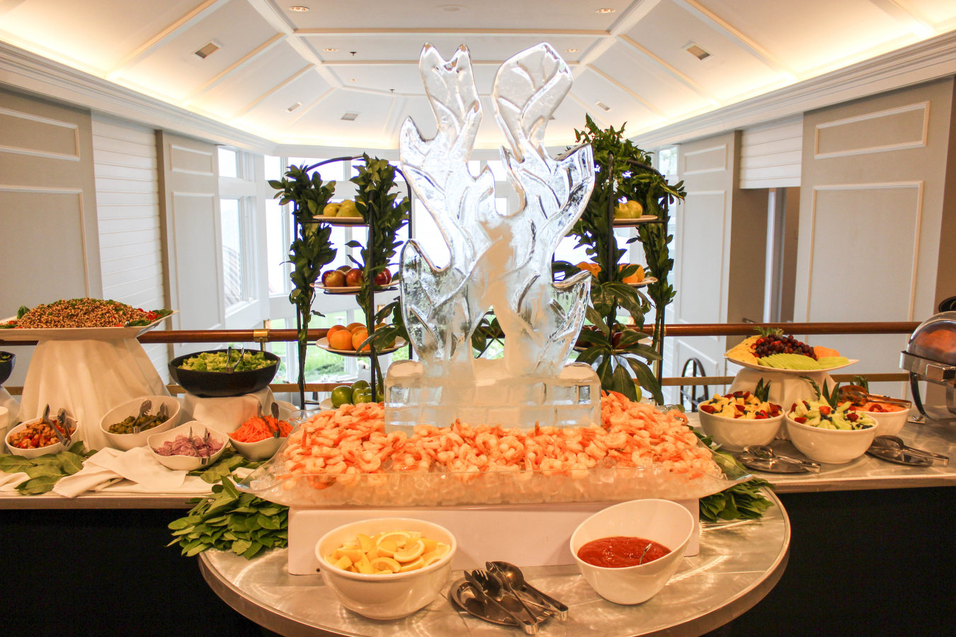 Shrimp cocktail buffet with ice sculpture centerpiece and fruit bowls