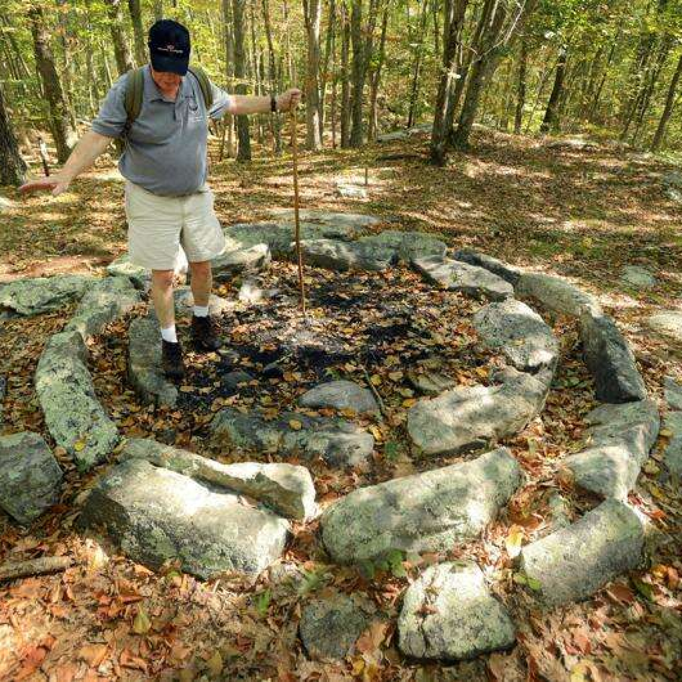 Man standing in center of circle of stones in a forest
