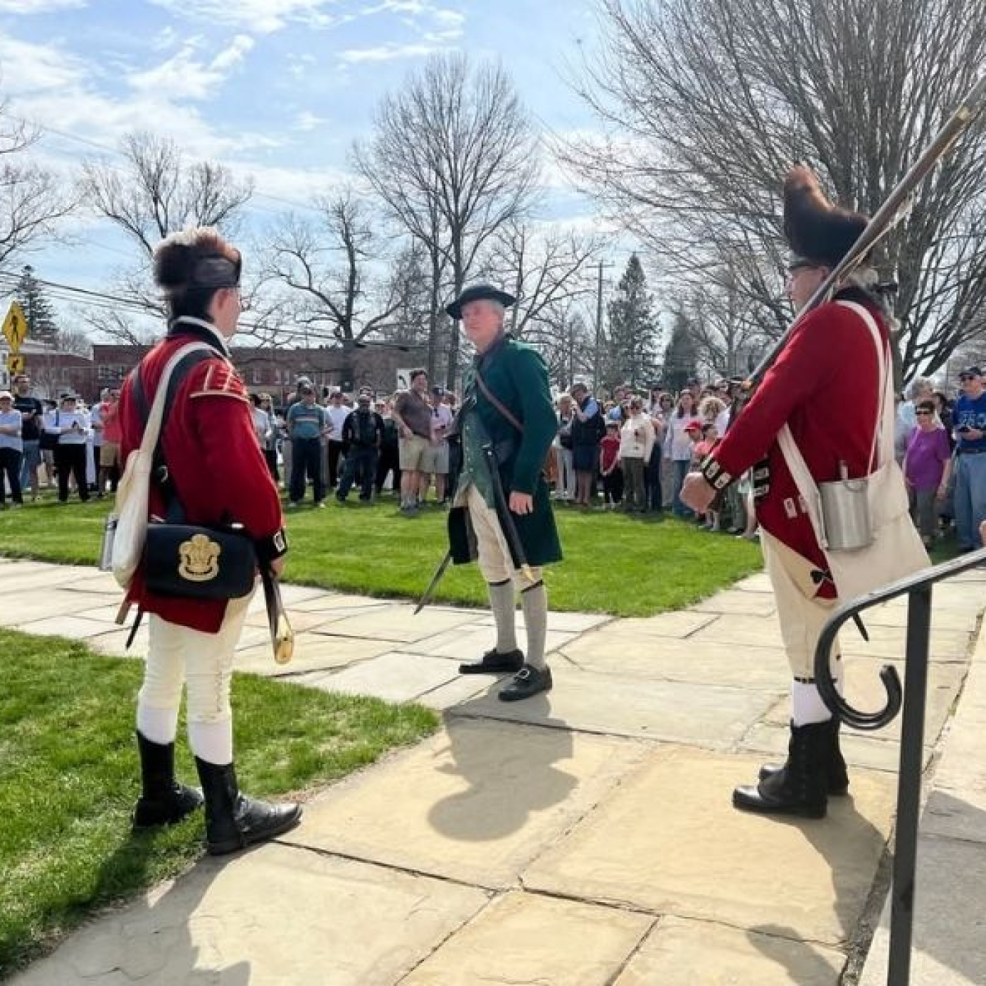 Two redcoats talking to a colonial patriot on the steps of the congregational church in Litchfield