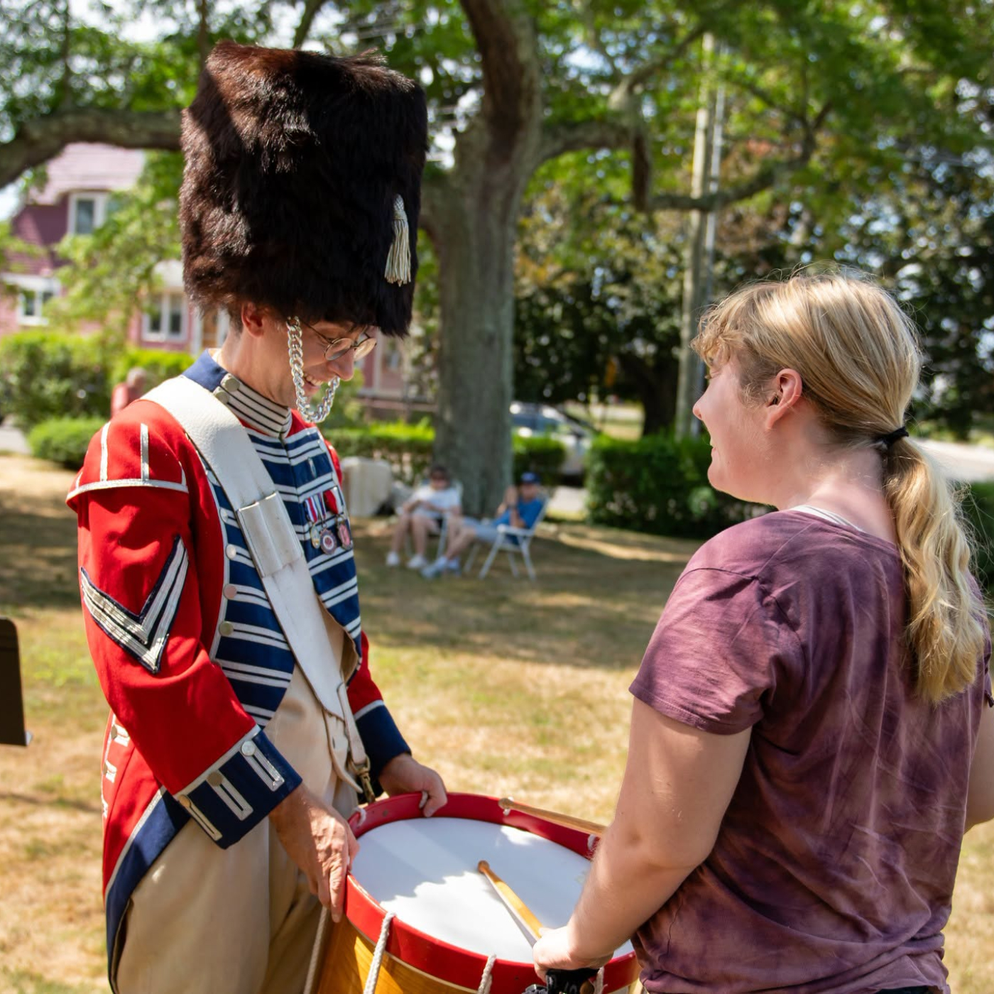 A revolutionary war reenactor and a museum visitor. 