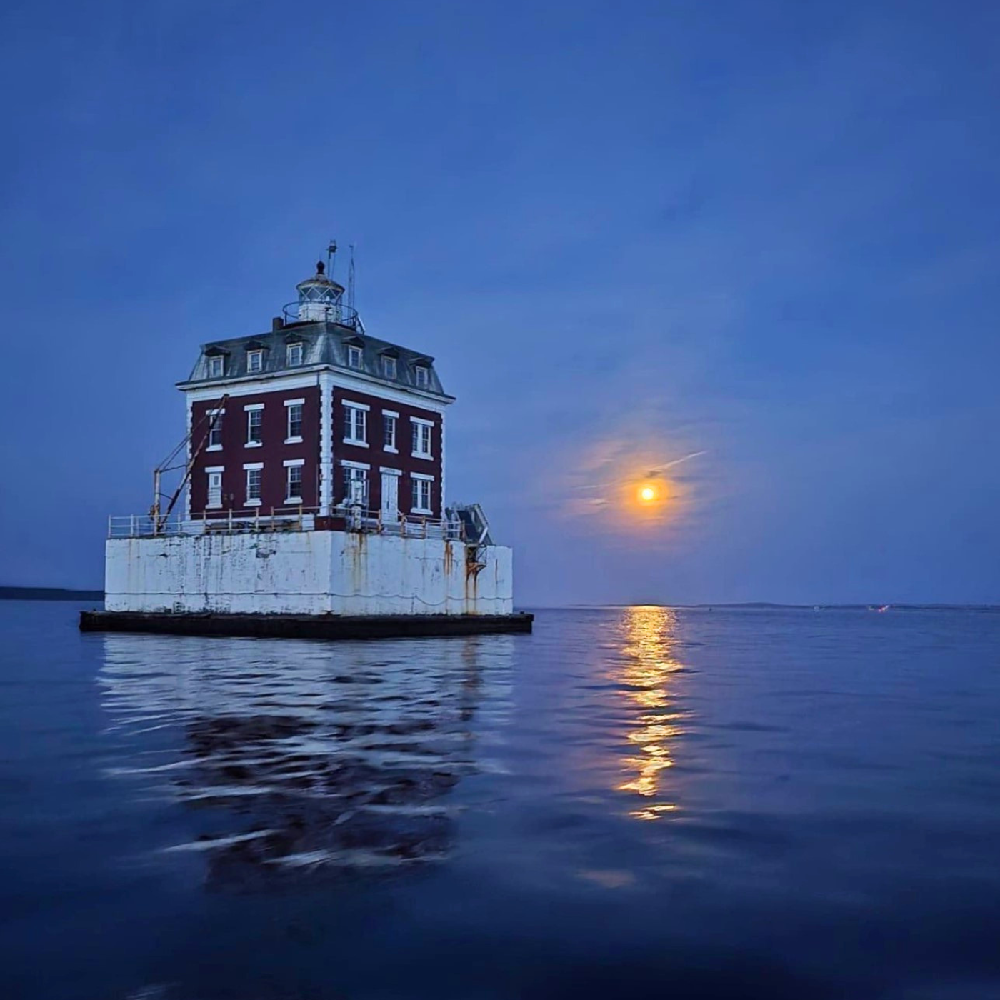 Full moon showing behind Ledge Light on the Thames River