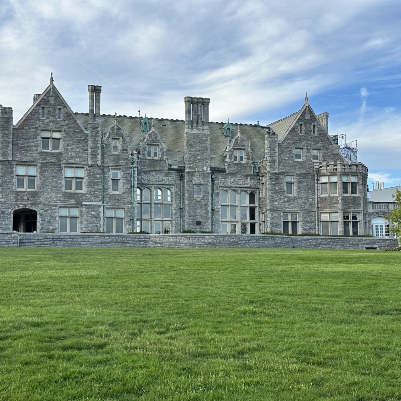 Branford House, a historic stone mansion overlooking a green lawn, featured on Thames River Heritage Park's Gilded Age tour.