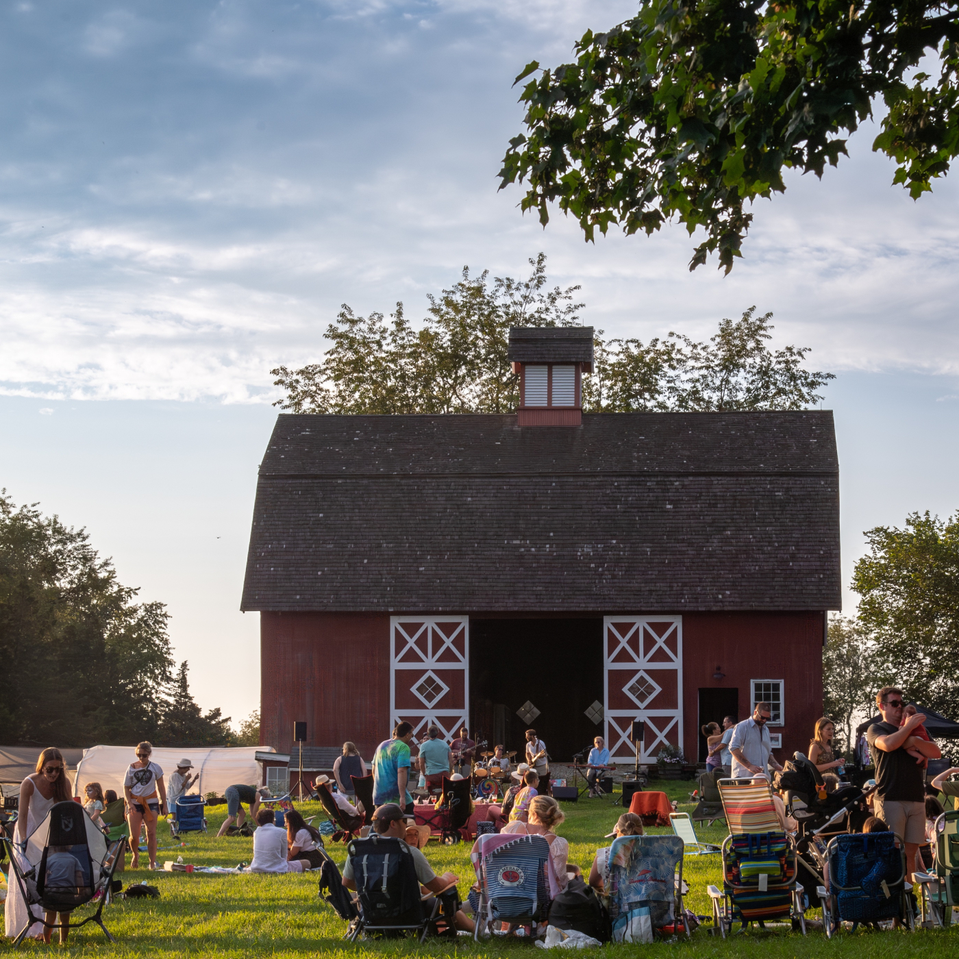Crowd enjoys music and food in front of Red Barn