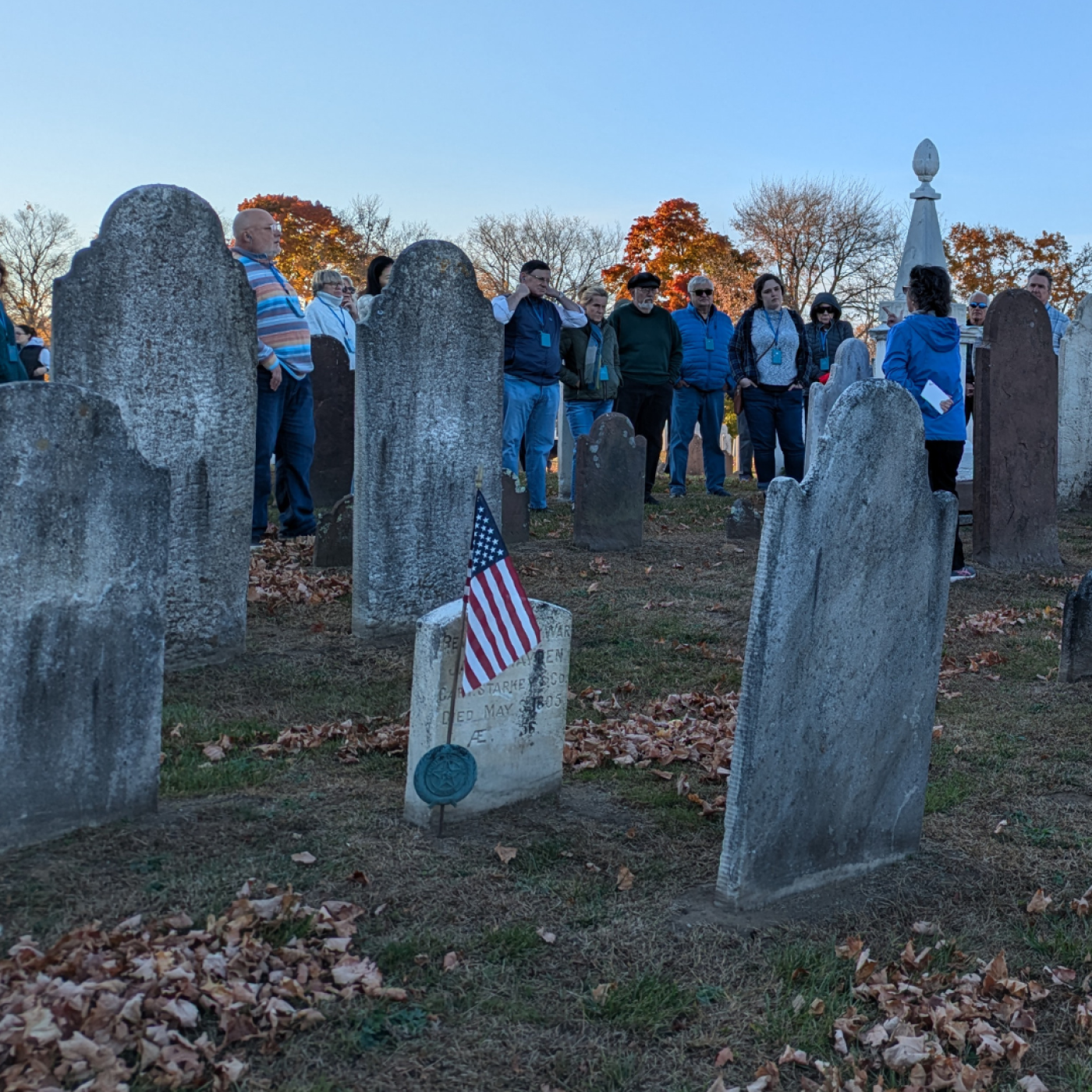 Gravestones at River View Cemetery with tour group in the background