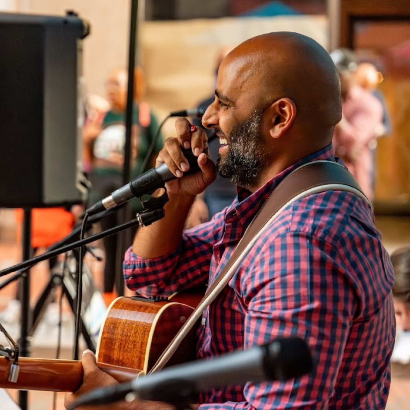 Mayor Arunan playing the guitar in front of an audience.
