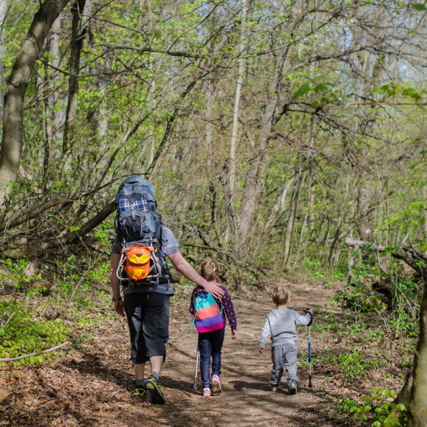 A family goes out for a hike on a sunny day.