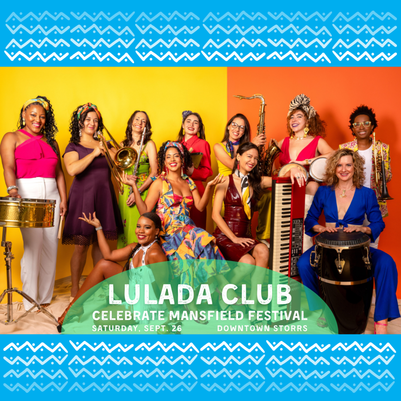 Eleven women in colorful outfits pose with their instruments