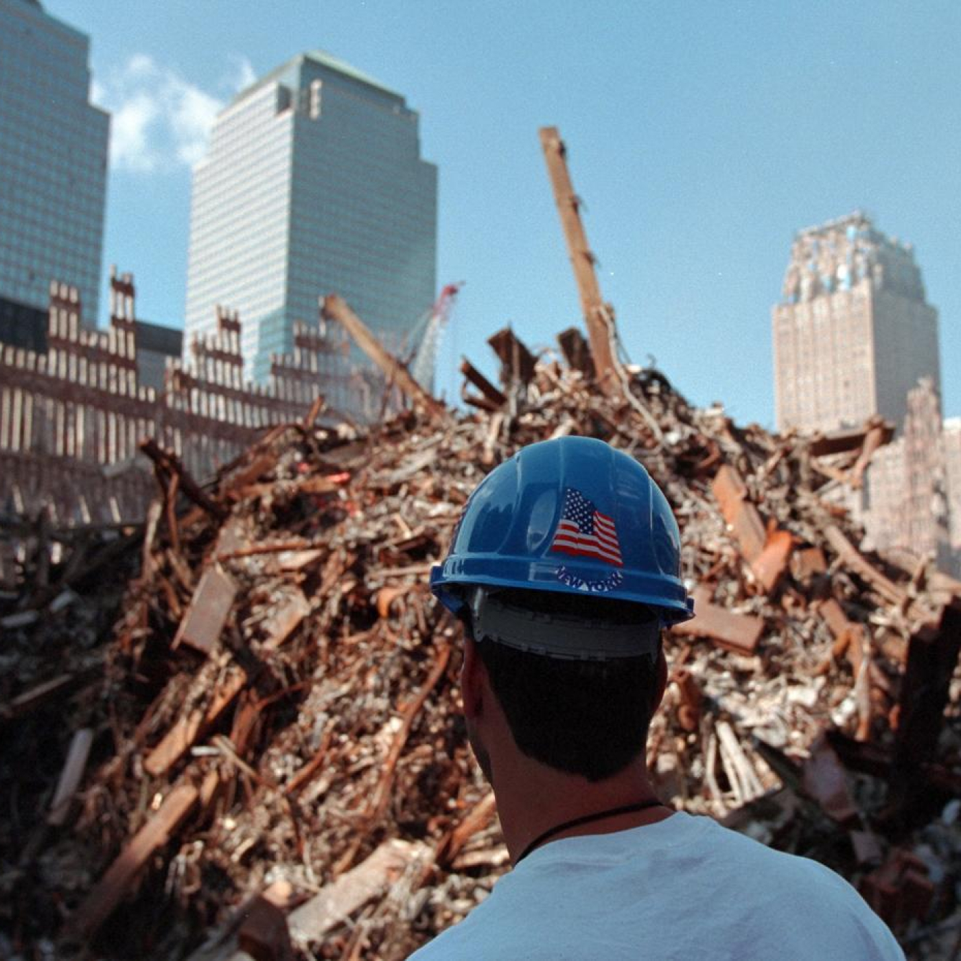 A new york first responder looking at the extent of the damage before him, which includes rebar and rubble. 