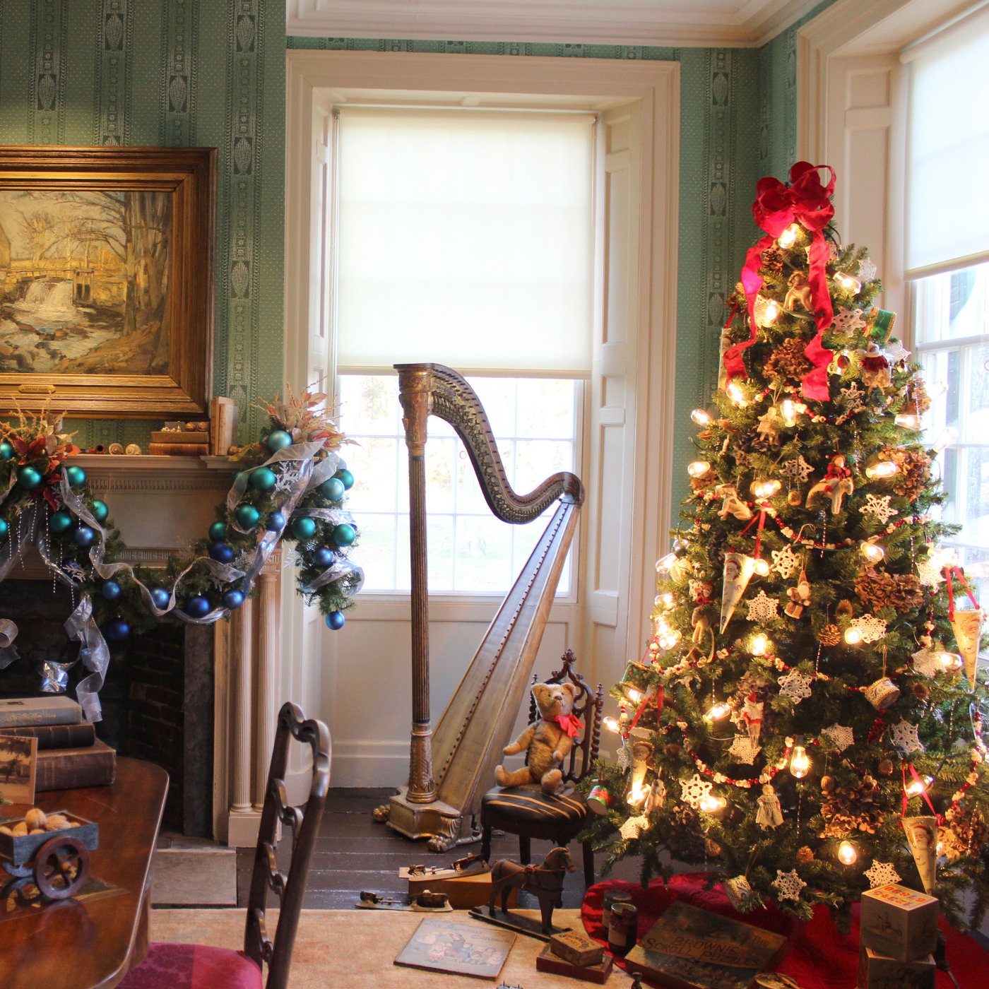 The historic parlor at the Florence Griswold Museum decorated for the holidays: a lit Christmas tree and decorated mantel