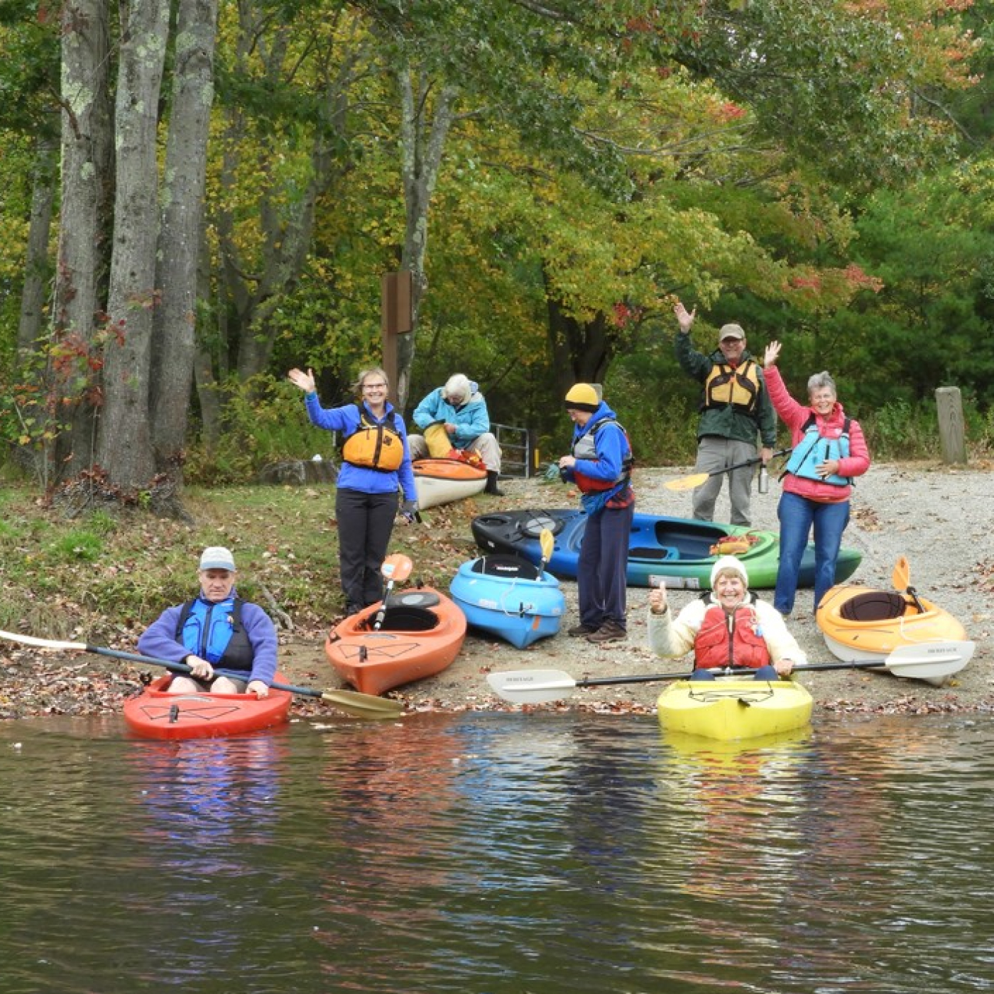 Group of kayakers waving