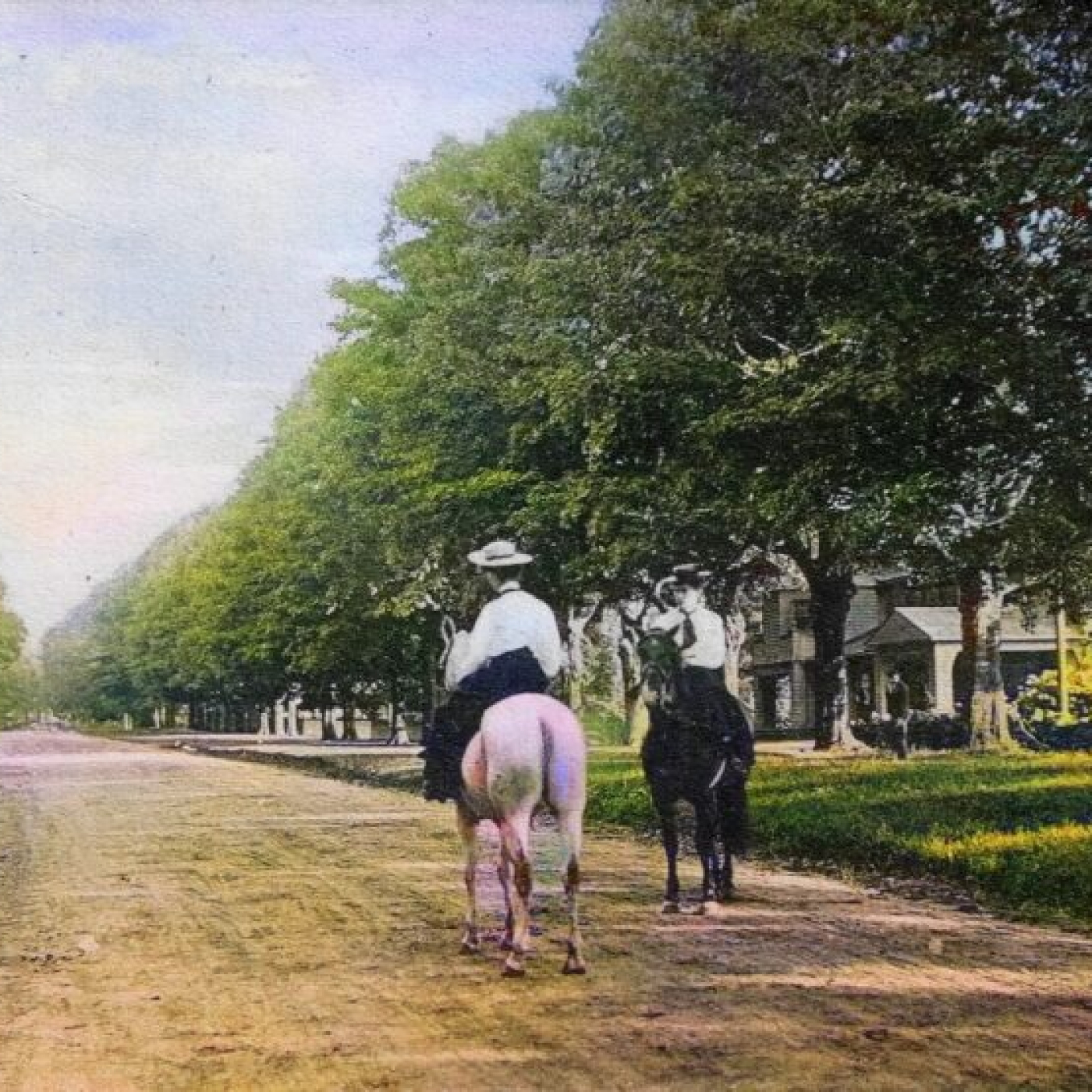 two people on horses going down old main street