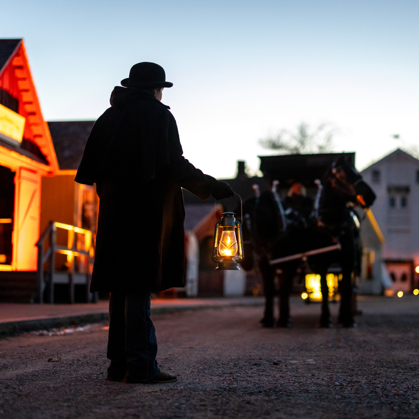 Horse drawn carriage led by lantern light