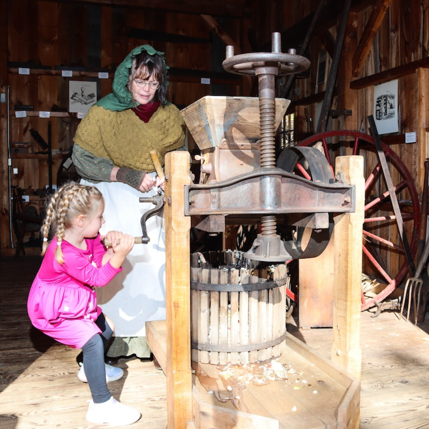 Turning the crank on the antique cider press. 