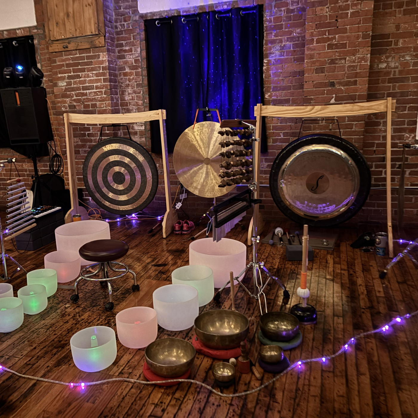 Gongs, colorful singing bowls, and lights setup for sound meditation