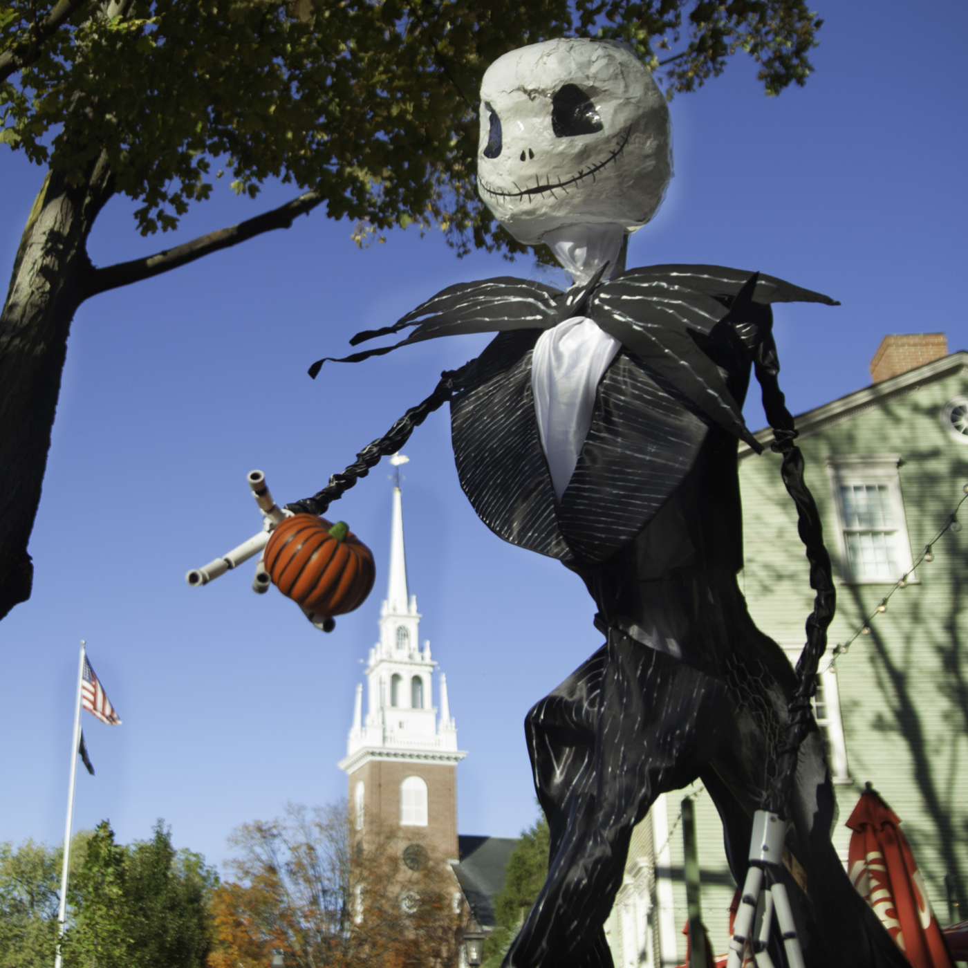An image of a scarecrow holding a pumpkin 
