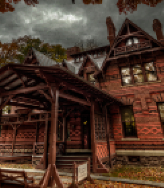 Victorian brick house under cloudy sky in autumn with wooden porch