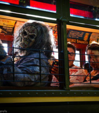 People in gruesome zombie costumes sitting inside a trolley car