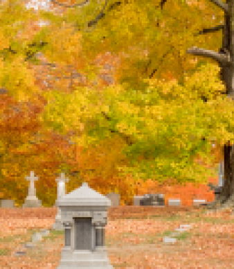 Autumn cemetery with tombstones and colorful fall foliage