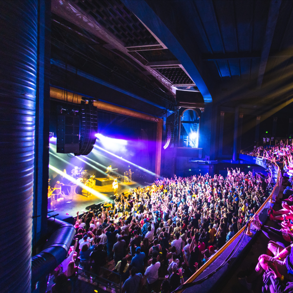 Crowd enjoying live concert with stage lights and band performing