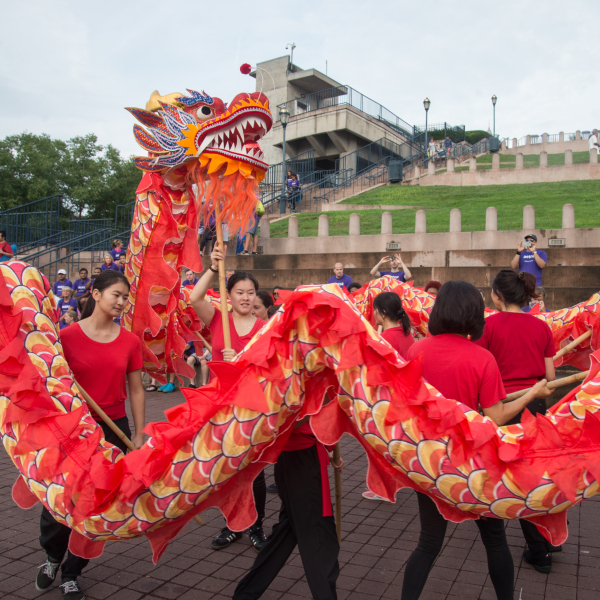 Group performing traditional red and gold Chinese dragon dance outdoors