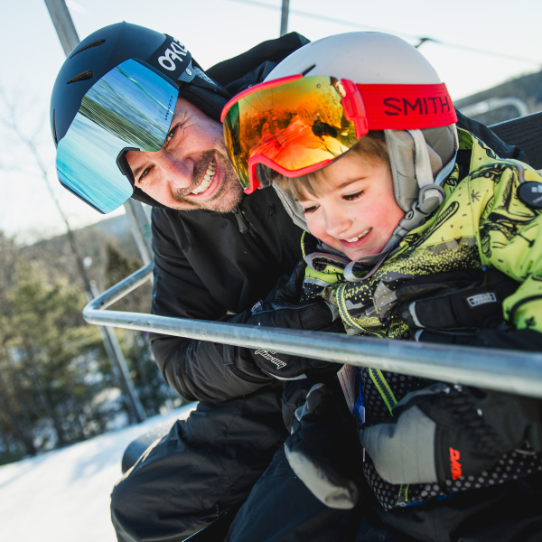 Dad and son smiling on chairlift