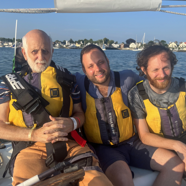 A father and his sons sailing on NESS's adaptive sailboat