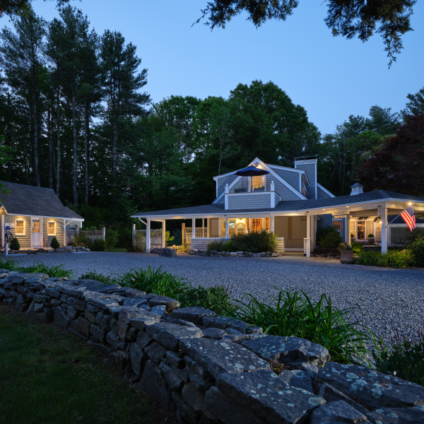 The main house and cottage at Abbey's Lantern Hill Inn illuminated at dusk