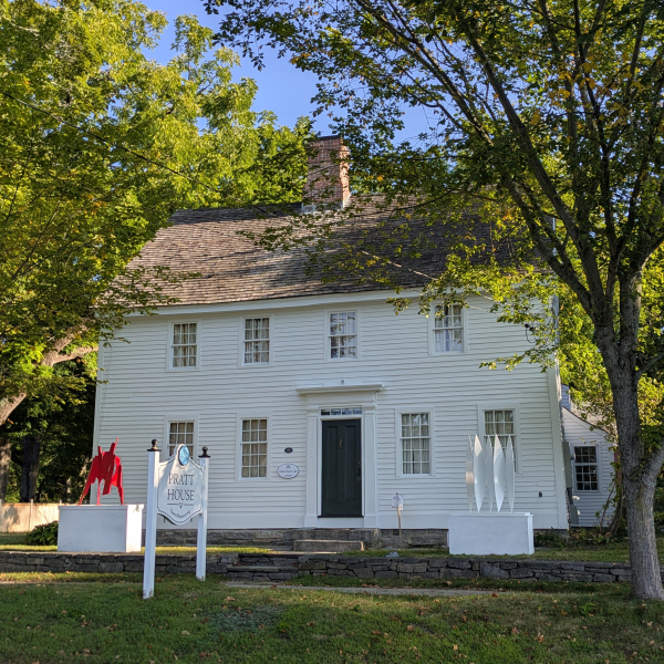 Pratt House in summer with leafy trees and modern art on display