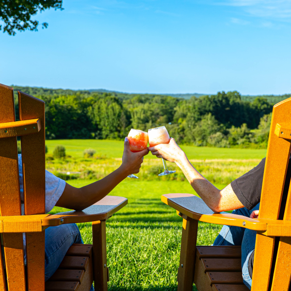 Adirondack chairs and glasses of slushy against a view from the winery