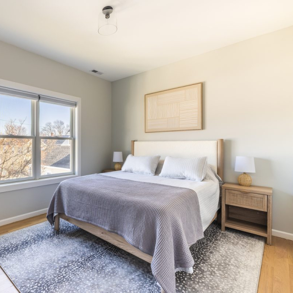 Queen guest room with soft coastal palette, two closets, and bedside charging stations.