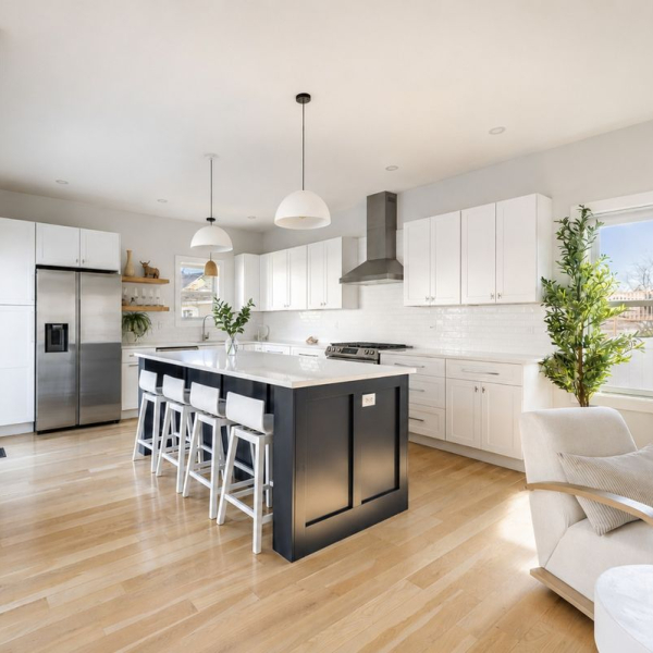 Bright chef’s kitchen with oversized quartz island, stainless appliances, and a fully stocked cooking setup 