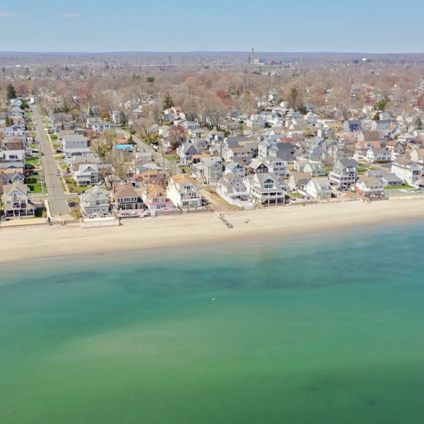 Aerial view of quiet residential Wildemere Beach and Long Island Sound, with Walnut Beach Luxury House near the shoreline.