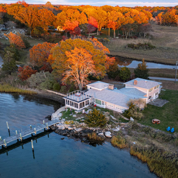 Aerial view of 26 Schoolhouse at the edge of the Mystic River, amid autumn marsh and trees