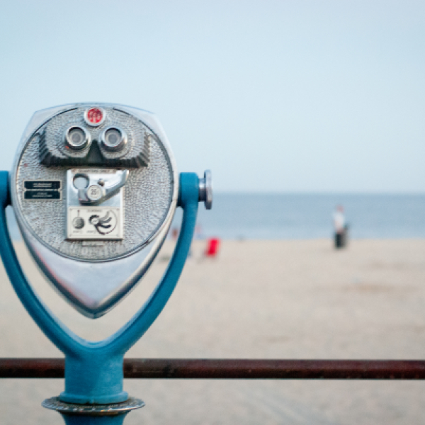 Coin-operated binocular viewer at beach with ocean background