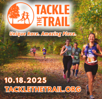 Smiling runners on the trail surrounded by fall foliage