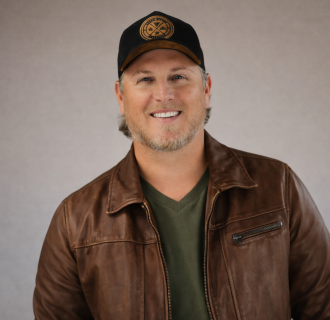 Jason Blaine in front of a tan background