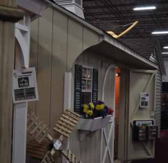 A picture of a few sheds for sale at a Home Show or Expo.