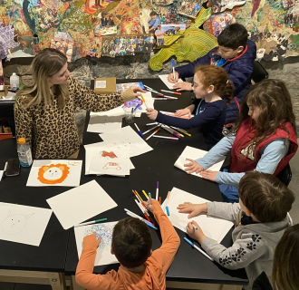 Art educator from the american mural project running an art activity from a previous family day.