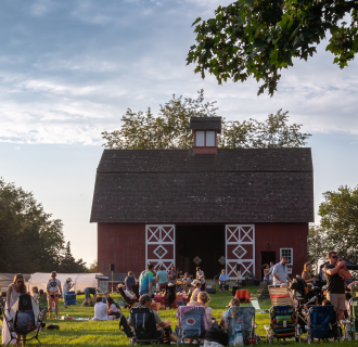 Crowd enjoys music and food in front of Red Barn