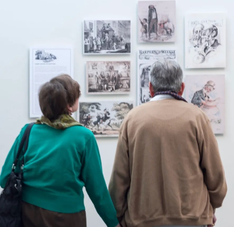 couple looking at a wall of paintings 