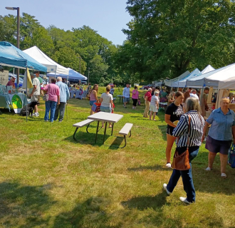 Vendor tents and market guests at the Voluntown Farmers Market. 