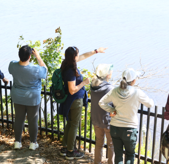 On the overlook of the Peace Sanctuary, a DPNC educator points out across the Mystic River. 
