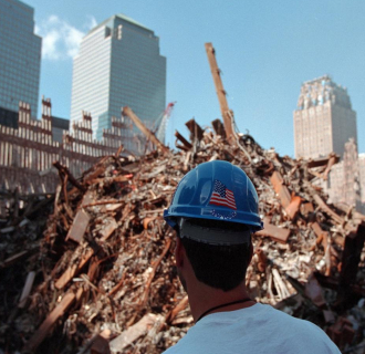 A new york first responder looking at the extent of the damage before him, which includes rebar and rubble. 