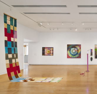 A view of a gallery with colorful painting and sculpture