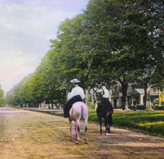 two people on horses going down old main street