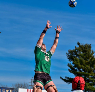 A rugby player leaps for the ball during a game